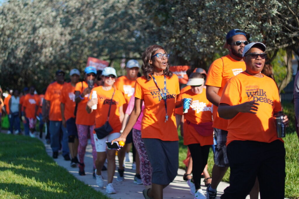 A group of volunteers involved in a Lauderhill community event organized by Commissioner Melissa P. Dunn. All participants have on orange t-shirts.